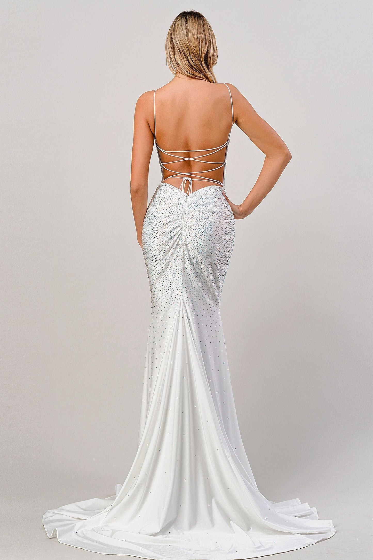 White evening gown with open back on a plain background