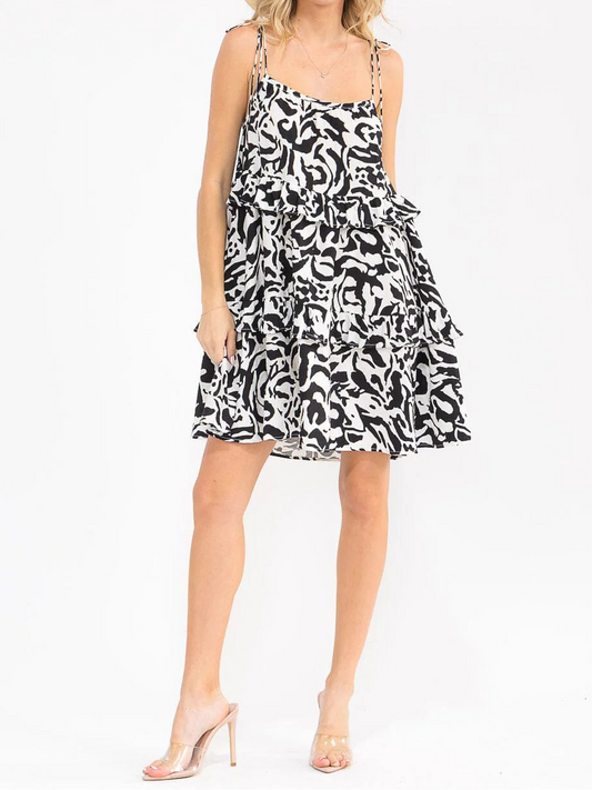 Woman wearing a black and white patterned dress on a white background