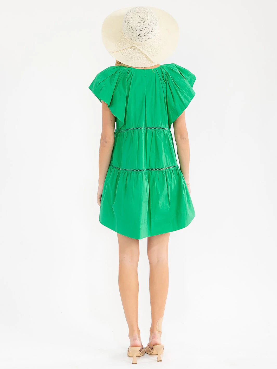 Person wearing a green dress and white hat on a white background