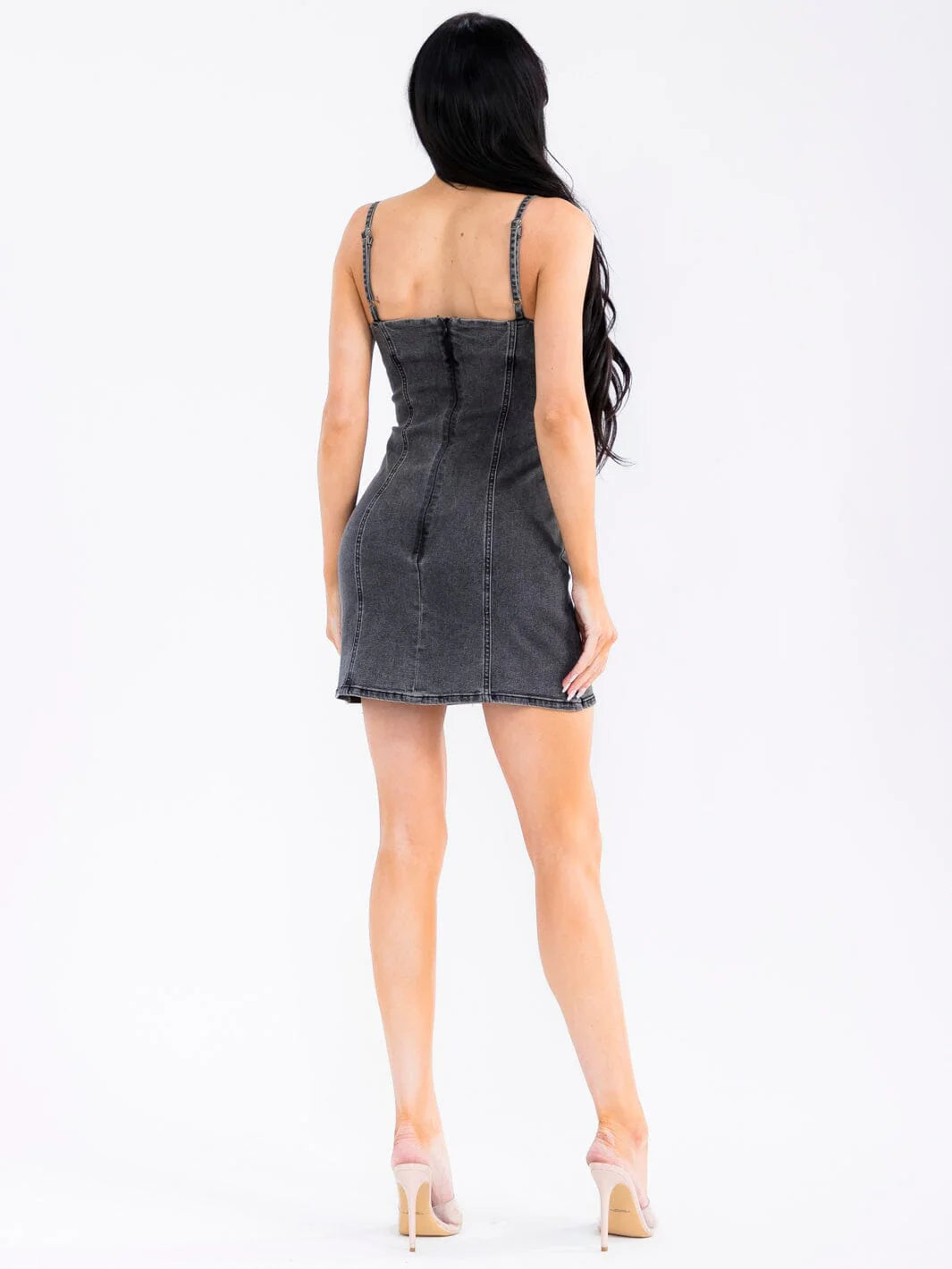 Woman wearing a black denim dress on a white background