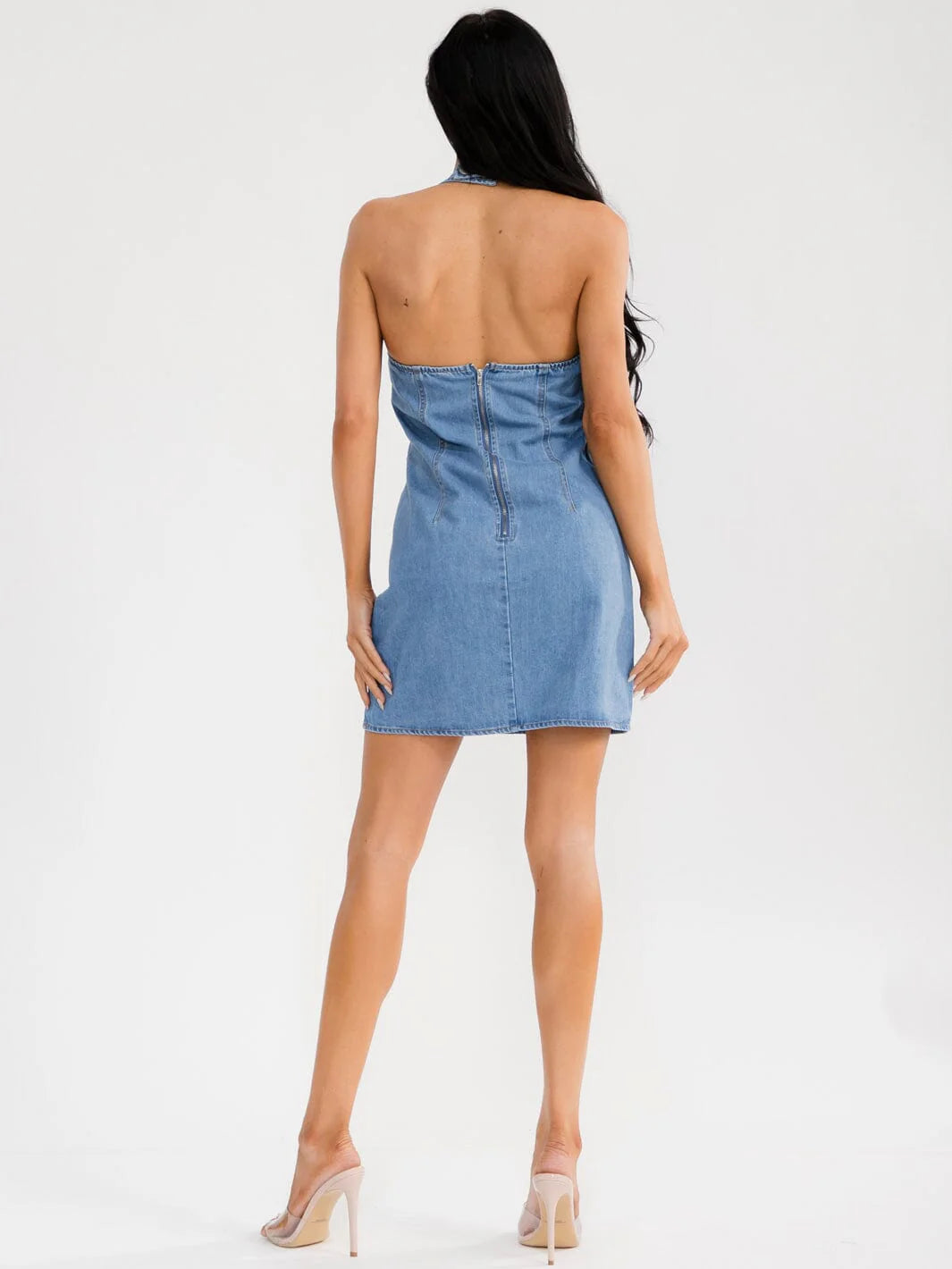 Woman wearing a blue denim dress on a white background