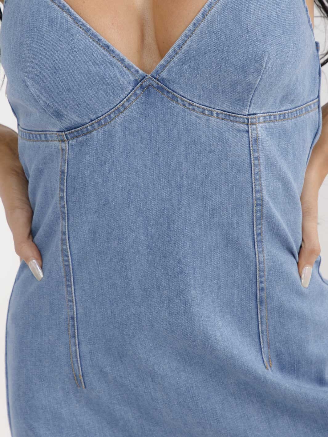 Close-up of a blue denim dress with a V-neckline.