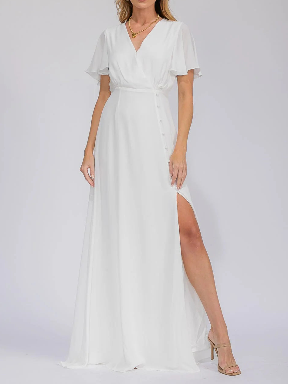 Woman wearing a white dress with a slit on a white background