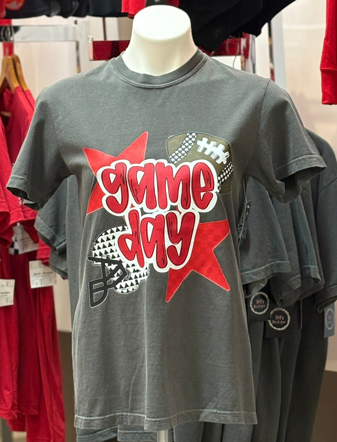 Gray t-shirt with 'game day' design on a mannequin in a store setting.