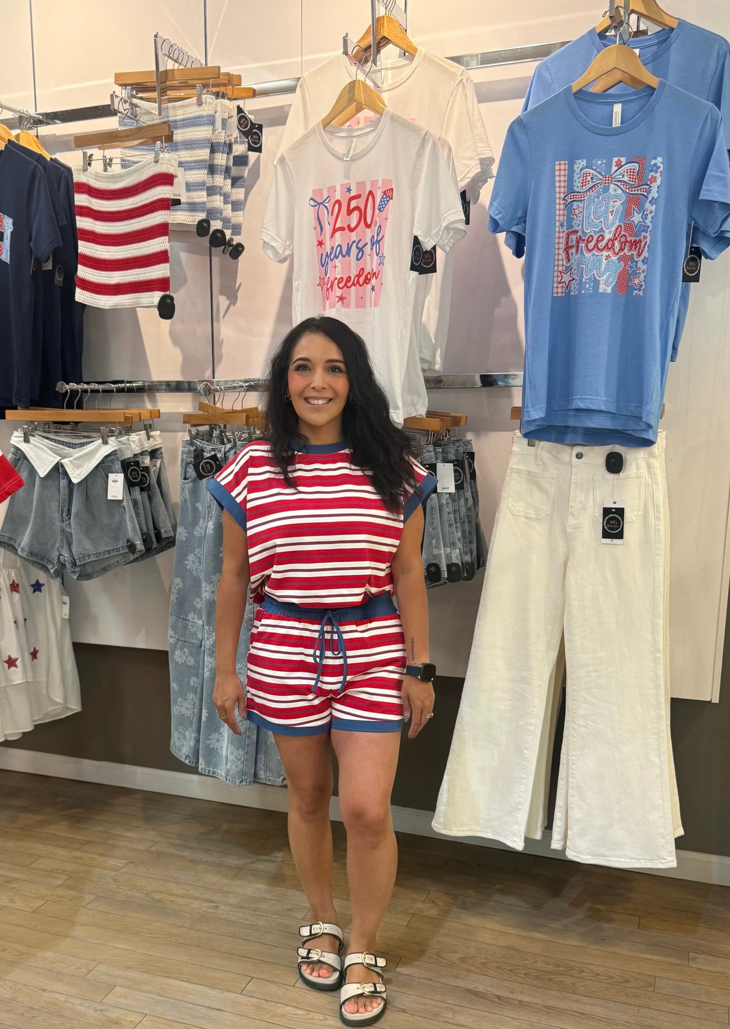 Woman standing in a clothing store with children's outfits on display