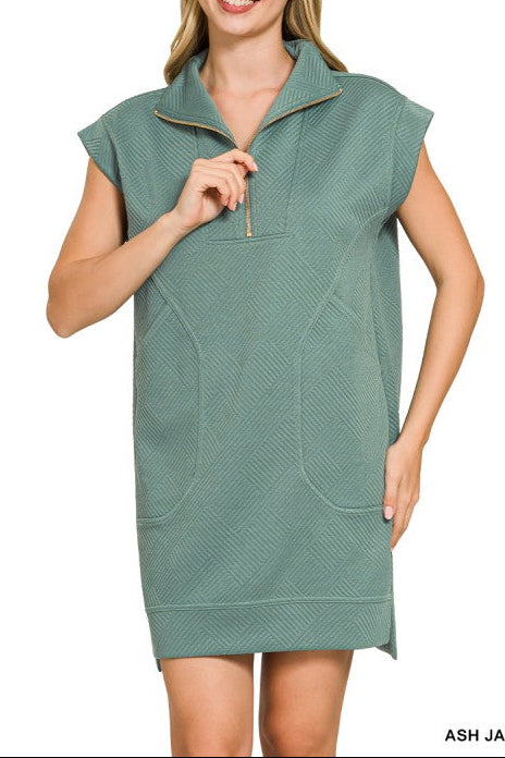 Woman wearing a green sleeveless dress with a zipper on a white background