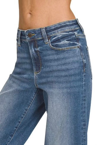 Close-up of a model wearing medium-wash blue denim jeans, showing the front waistband, button, belt loops, front and side pockets, and the upper thigh area. The word 'DARK' appears in the bottom right corner.