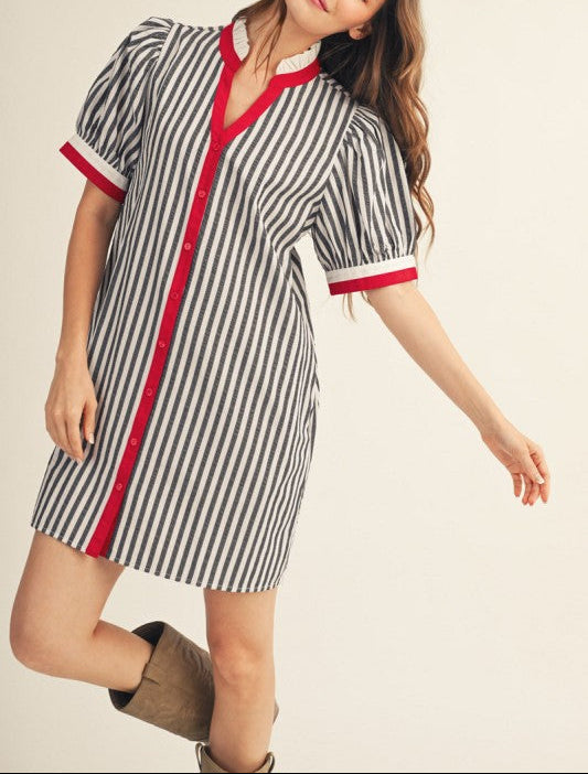 Woman wearing a striped dress with red accents on a plain background