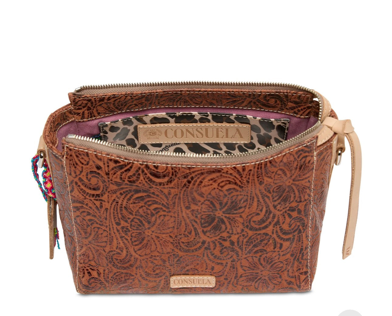 Brown leather bag with intricate patterns and visible brand name on a white background