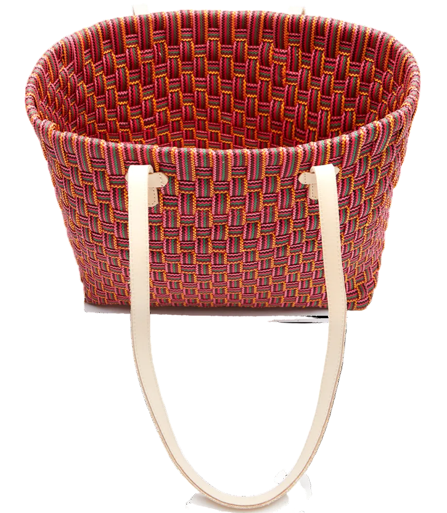 Woven basket with colorful pattern and white handles on a white background