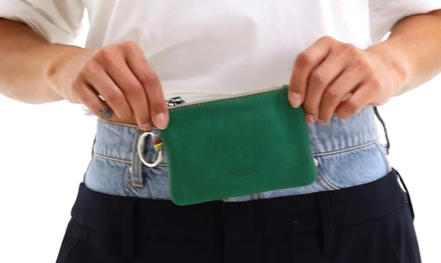 Person wearing a green waist bag with a white background