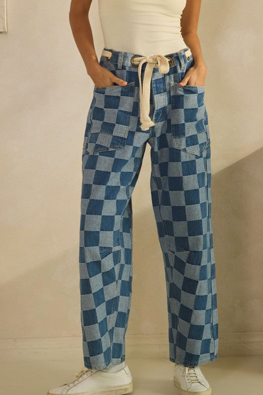 Person wearing blue checkered pants with a beige background