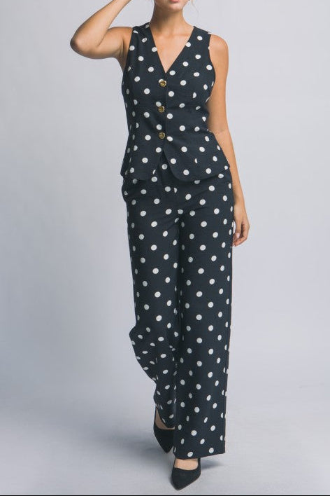 Woman wearing a polka dot jumpsuit on a gray background