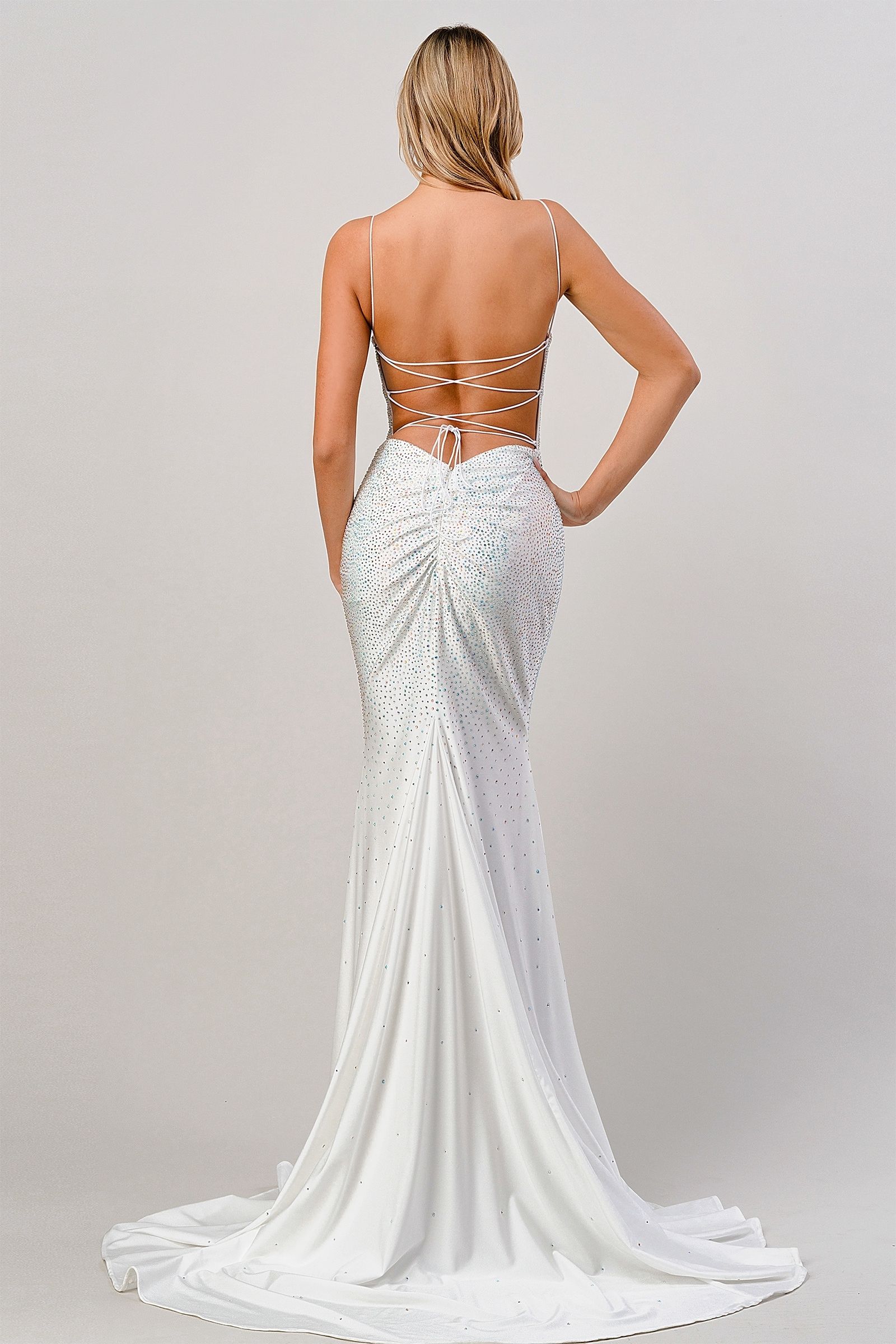 White evening gown with open back on a plain background