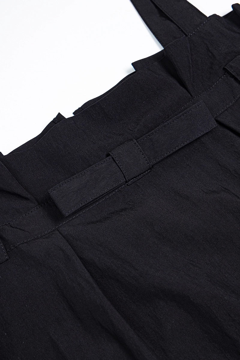 Close-up of black pants with a belt on a white background