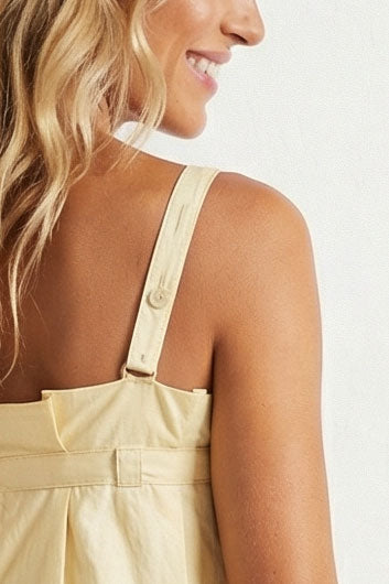 Woman wearing beige overalls on a white background