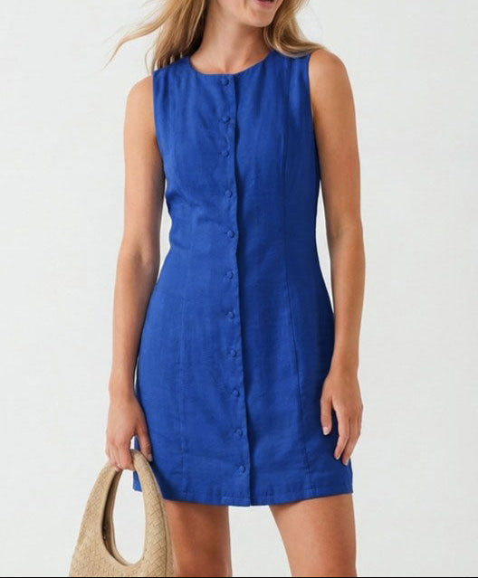 Woman wearing a blue dress with sunglasses and a beige bag on a white background