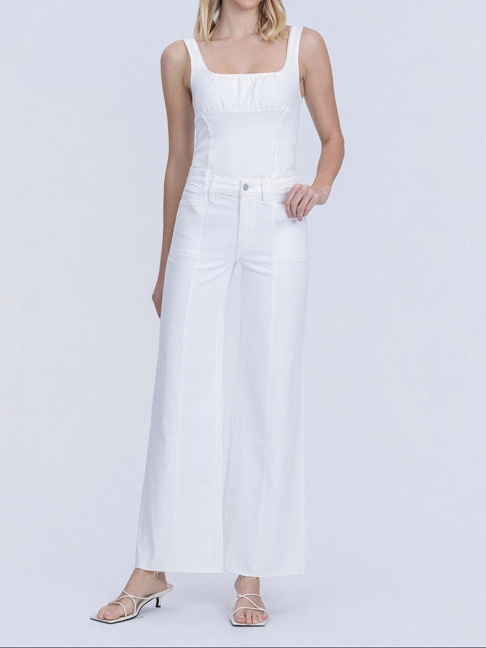 White wide-leg jeans worn by a person on a white background