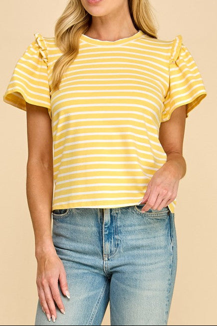 Woman wearing a yellow and white striped top with ruffled sleeves against a beige background