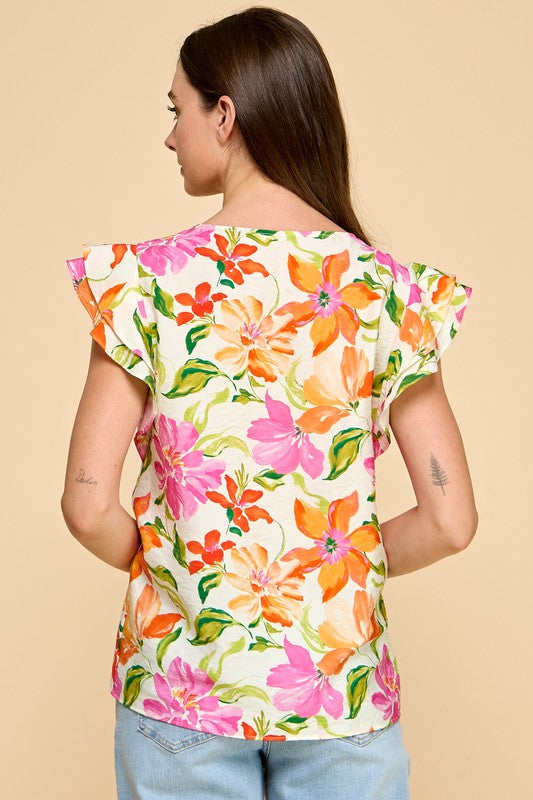 Woman wearing a colorful floral top on a beige background
