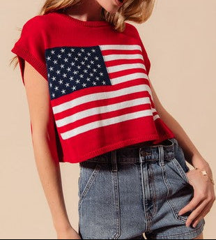 Woman wearing a red sweater with an American flag design on a beige background