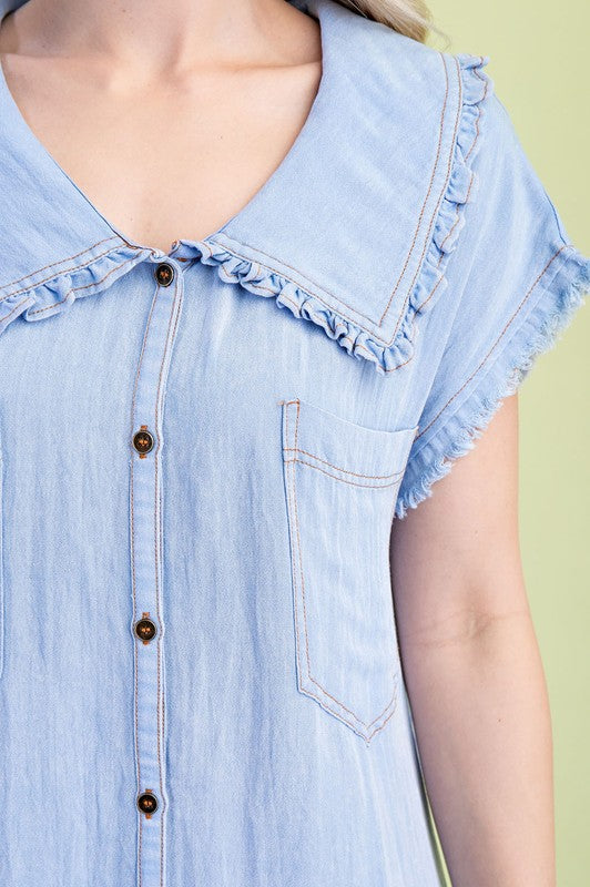 Light blue denim shirt with ruffled collar on a green background