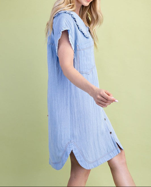 Woman wearing a light blue dress against a green background