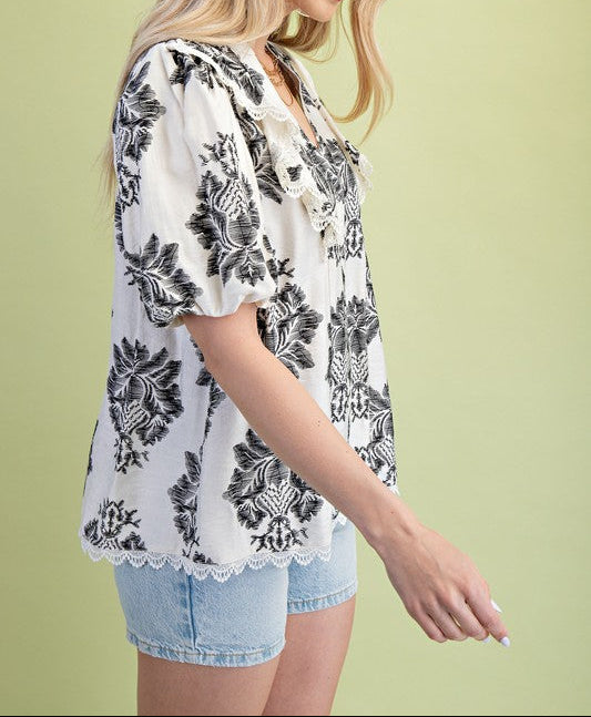 Woman wearing a floral blouse and denim shorts on a green background