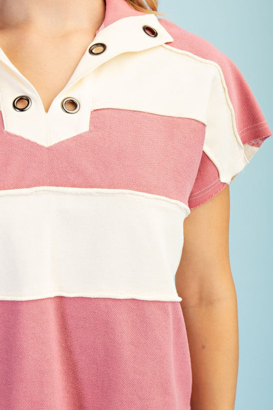 Close-up of a pink and white striped shirt with button details on a light blue background