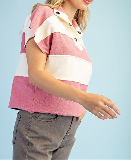 Woman wearing a pink and white striped shirt against a light blue background