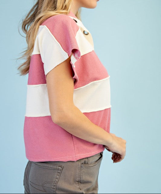 Woman wearing a pink and white striped shirt against a light blue background