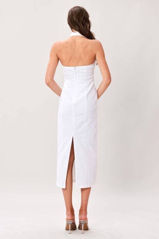 Woman wearing a white strapless dress with a slit on a plain background