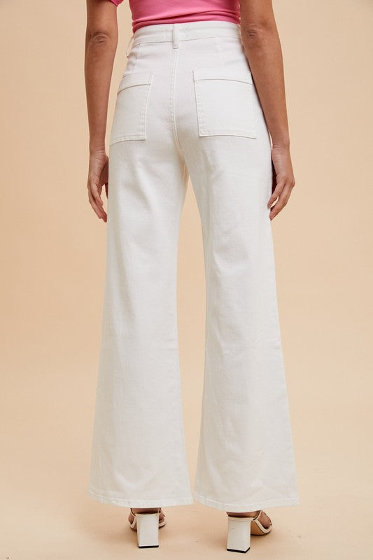 Person wearing light-colored wide-leg pants on a beige background