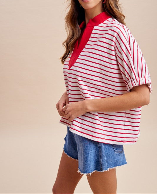 Woman wearing a red and white striped shirt with a red collar on a beige background