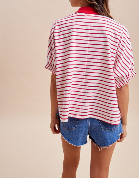 Woman wearing a red and white striped shirt and denim shorts on a beige background