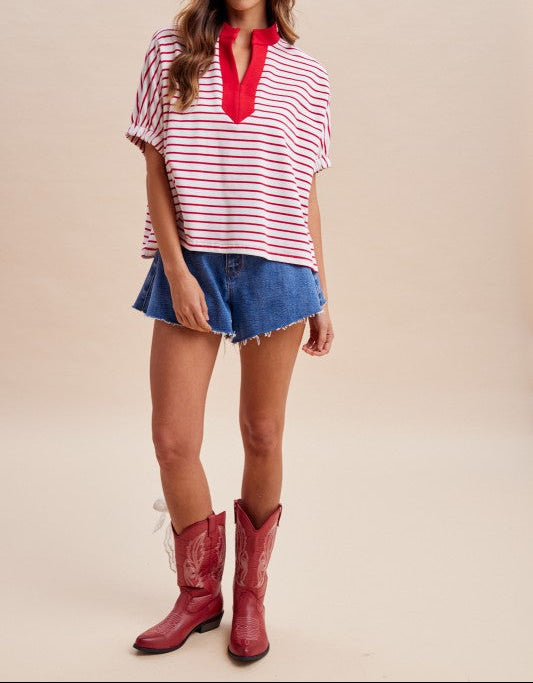 Woman wearing a red and white striped top, denim shorts, and red cowboy boots on a beige background