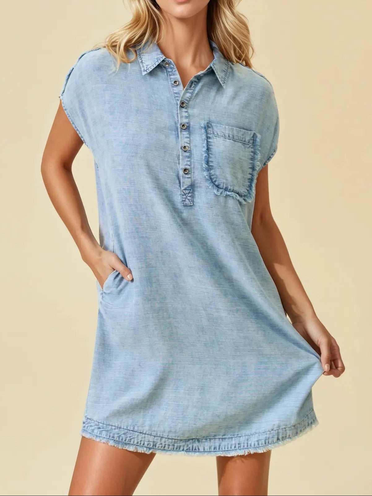 Woman wearing a light blue denim dress against a beige background