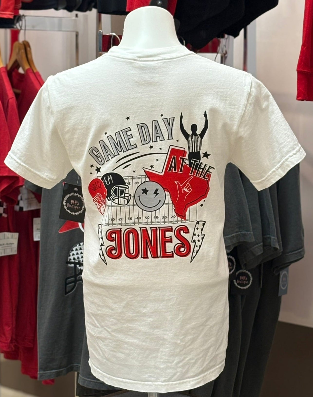 White t-shirt with 'Game Day Jones' design on a mannequin in a store setting.