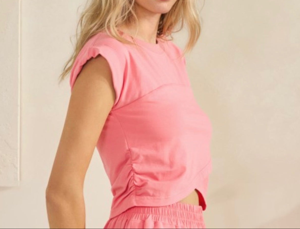 Woman wearing a pink outfit against a beige background