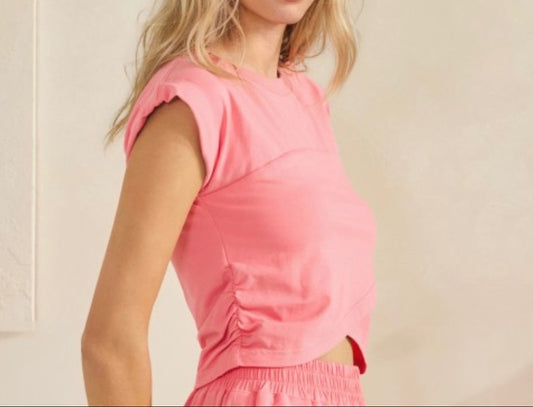 Woman wearing a pink outfit against a beige background