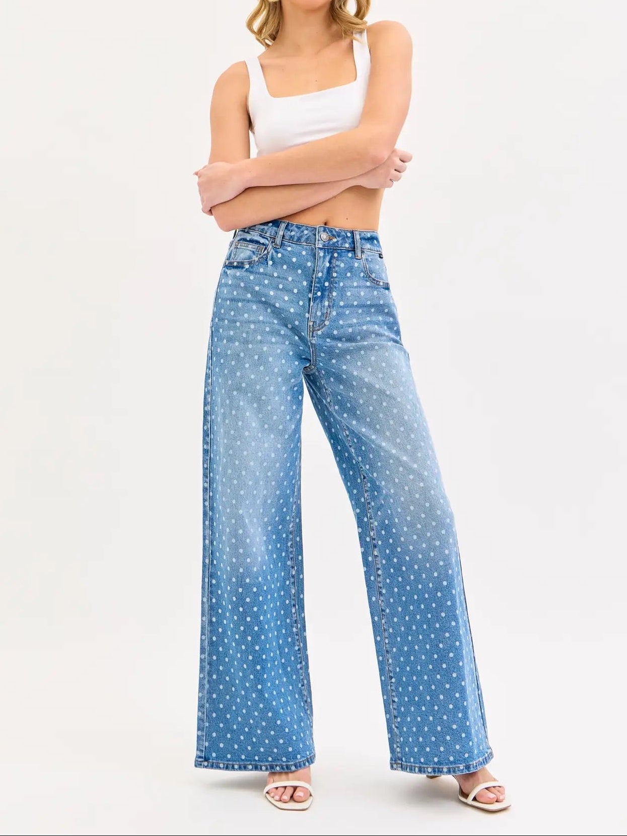 Woman wearing blue polka dot jeans on a white background