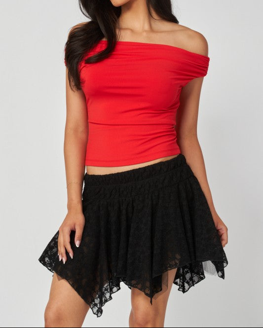 Woman wearing a red off-shoulder top and black skirt on a white background