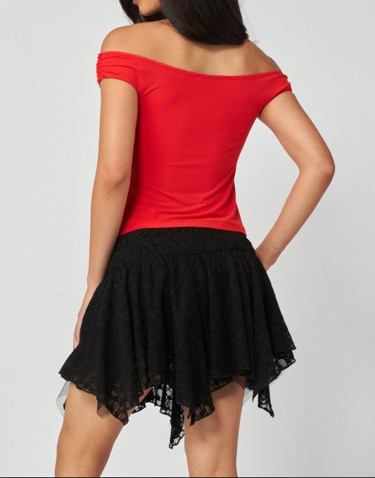 Woman wearing a red off-shoulder top and black skirt on a white background