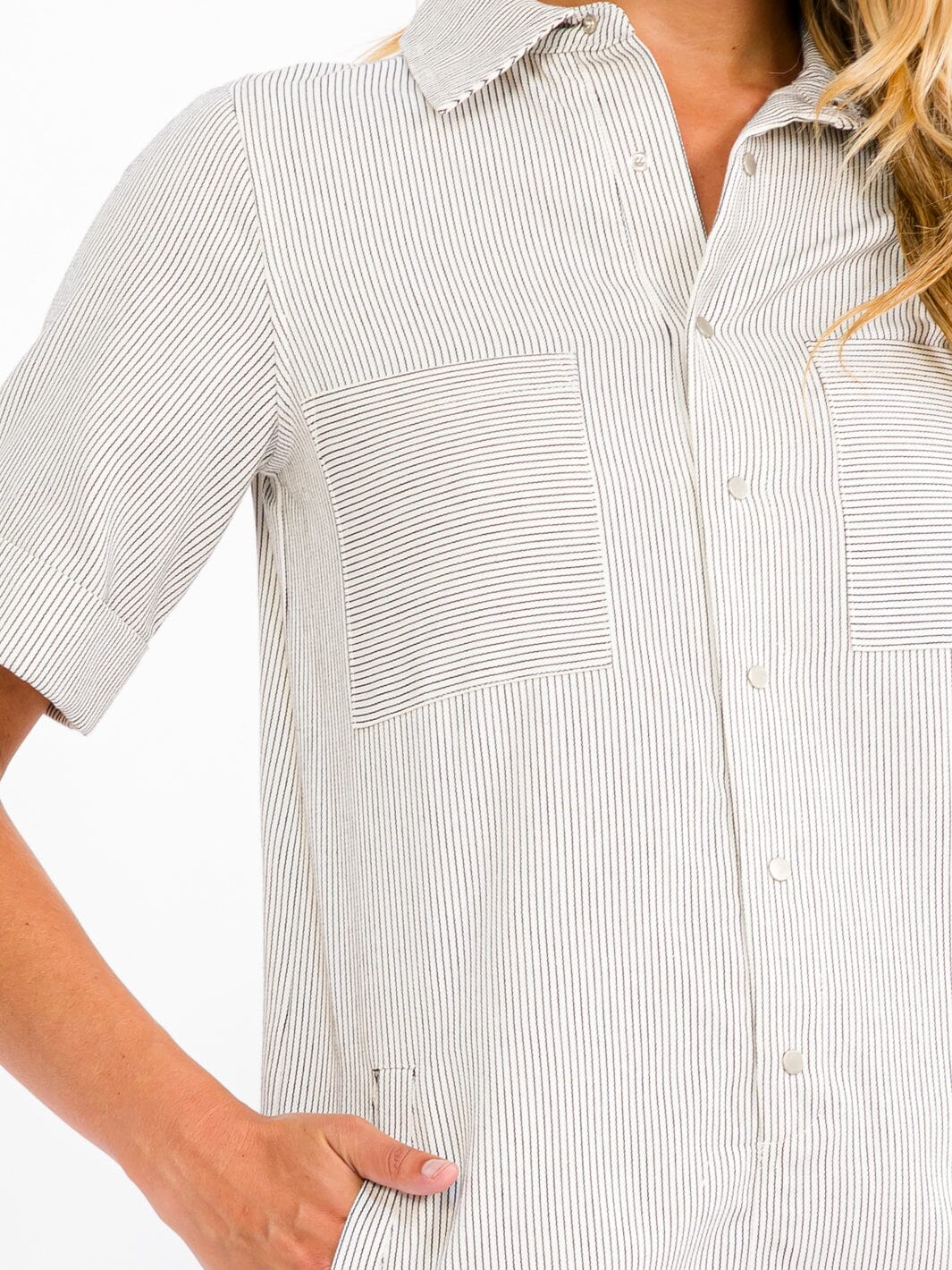 Close-up of a person wearing a white and gray striped shirt with a collar.