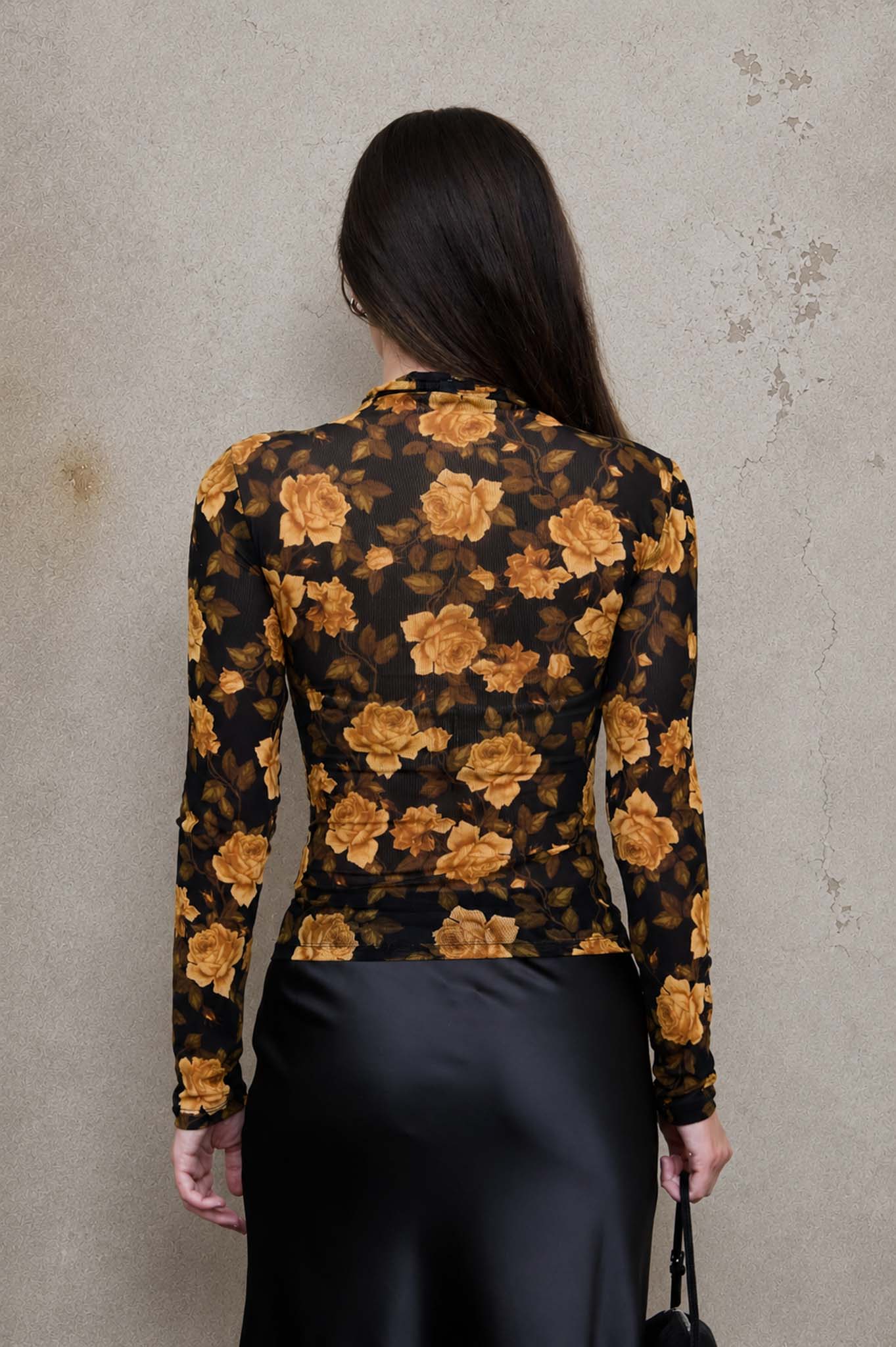 Woman wearing a floral blouse with a plain background