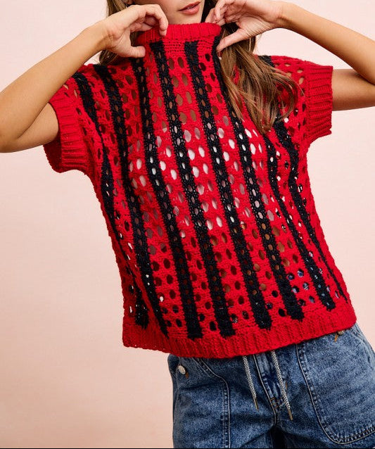 Woman wearing a red knitted top with black patterns on a beige background