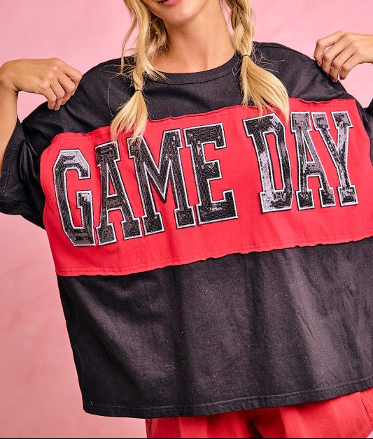 Woman wearing a black and red 'GAME DAY' shirt against a pink background