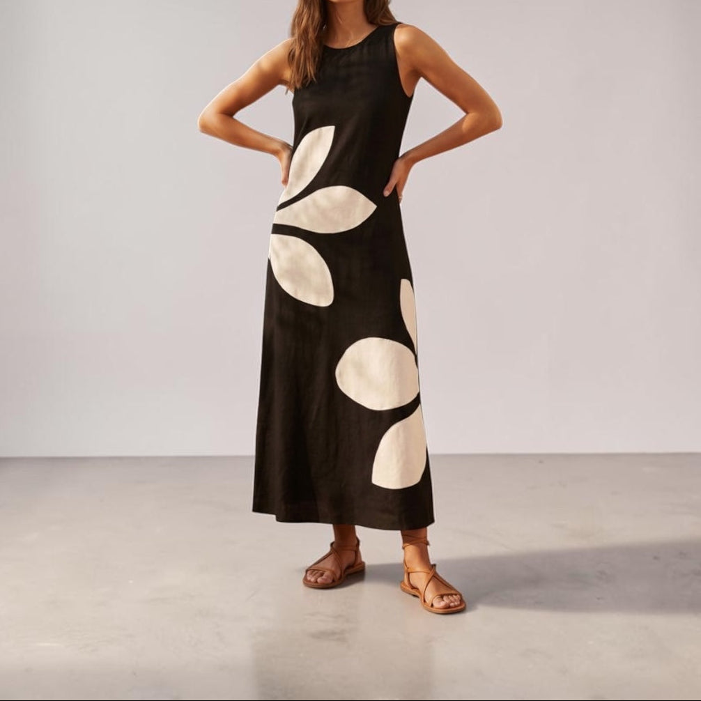 Woman wearing a black dress with white polka dots against a plain background