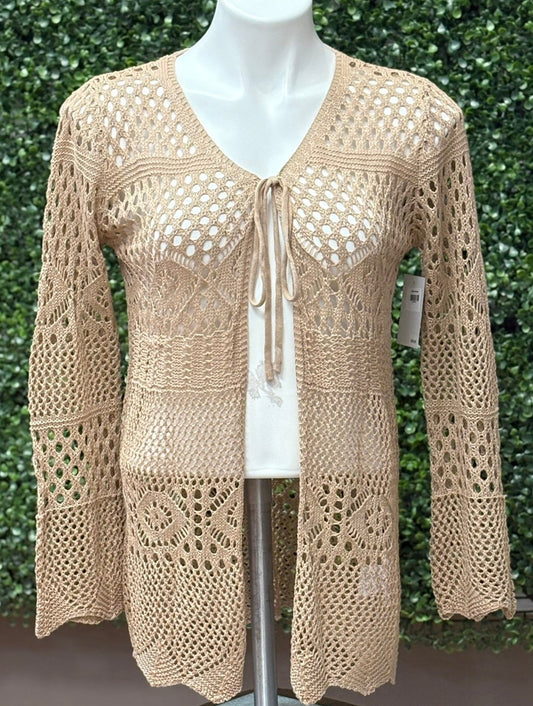 Tan crochet top on a mannequin against a green leafy background