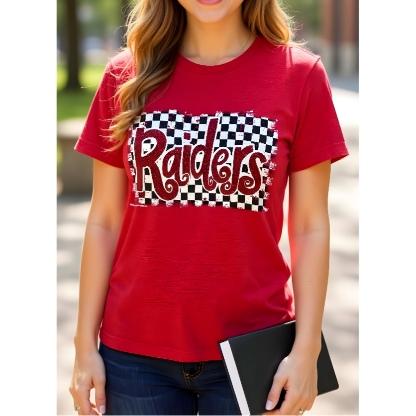 Person wearing a red t-shirt with 'Raiders' print outdoors